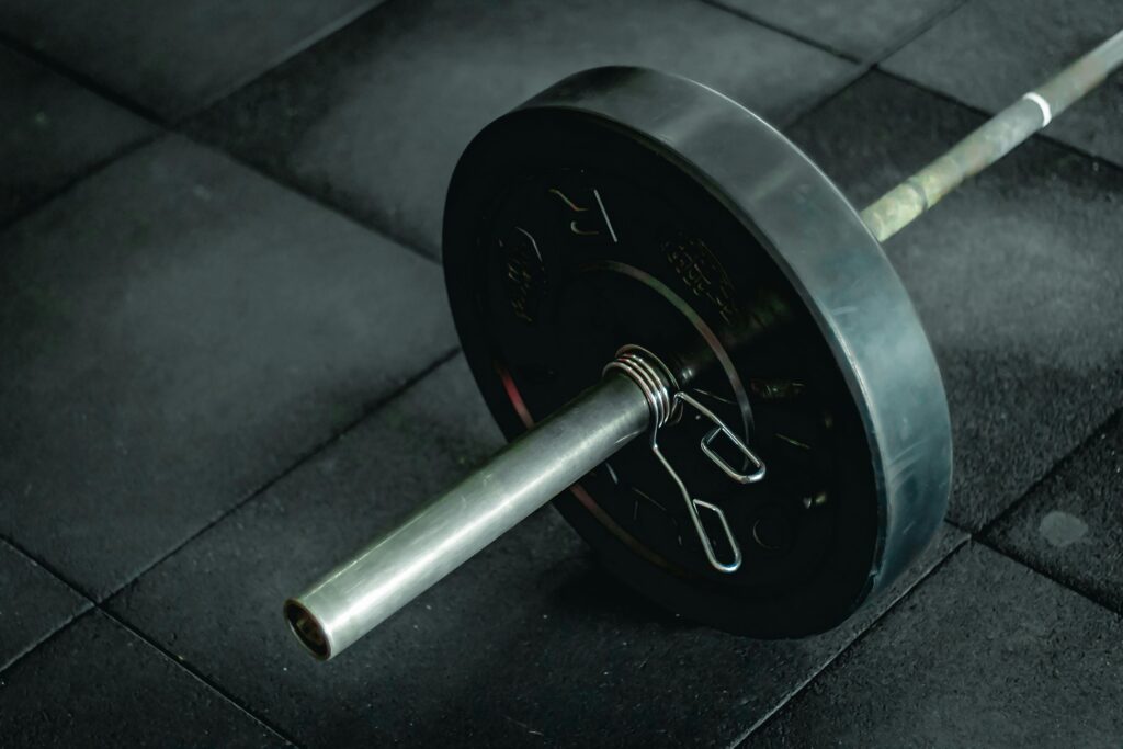 barbell loaded with a 45lb weight plate, resting on a gym floor